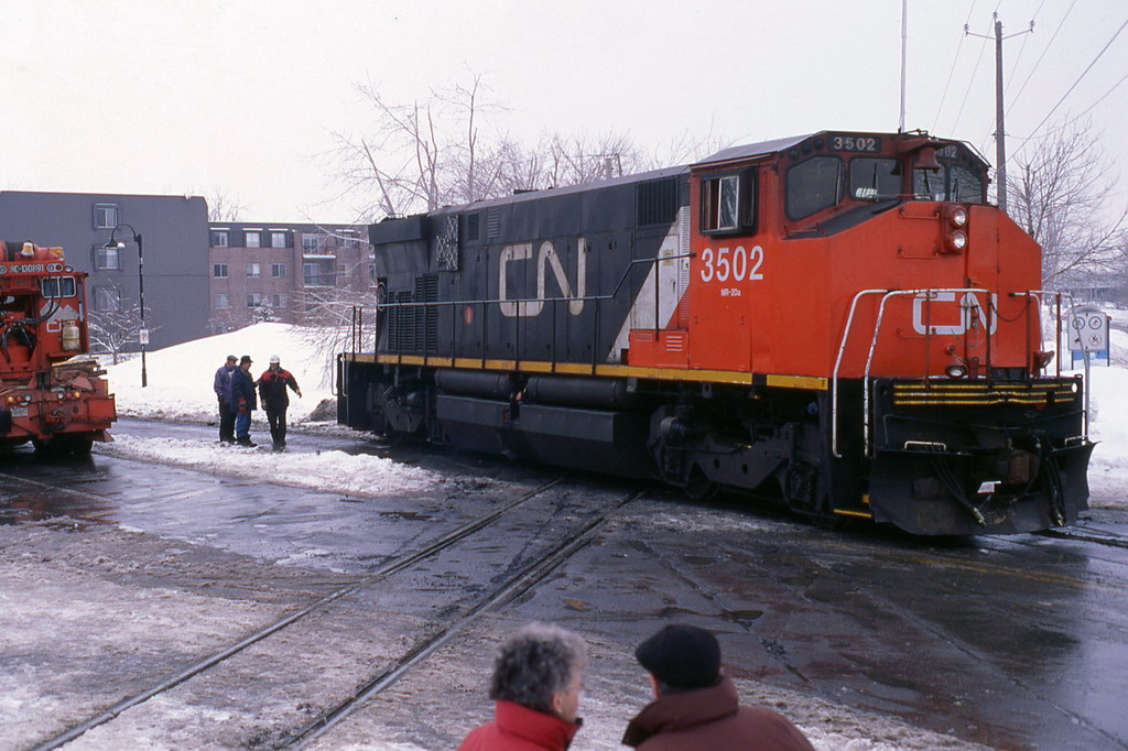 Locomotive at a level crossing at an angle to the railway line, on the asphalt