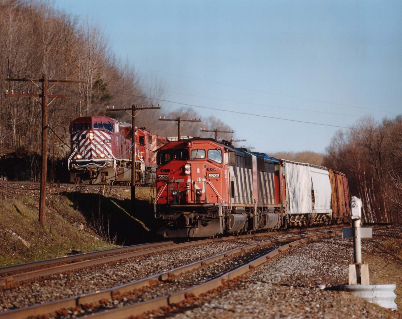 Southbound CN 5522,5501 idles at Dock Siding as CEFX 124, CP 6058, 5903 roars by.