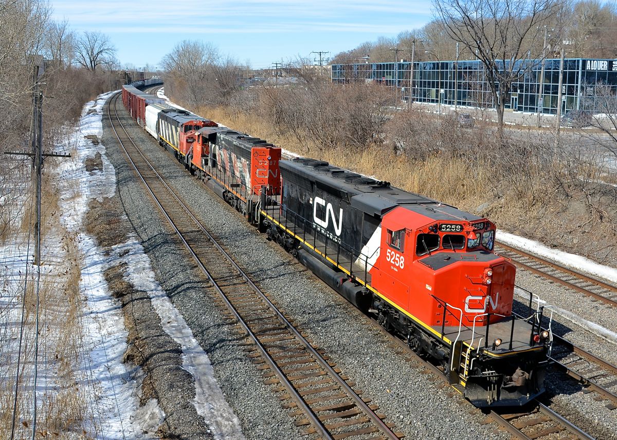 LNG test unit leading an insane lashup. A late CN 324 has a pair of SD40-2W's leading a Dash8 cowl (CN 5258, CN 5287 & CN 2417) as it heads east on CN's Montreal Sub. The lead unit had been converted to run on LNG fuel for test purposes a few years back and acquired SD45-like flares in the process. It has since been converted to regular diesel operation. The two lead units came into Montreal in the wee hours of the morning on CN 372. SD40-2W's have become very rare in the Montreal area, so this was a nice catch.