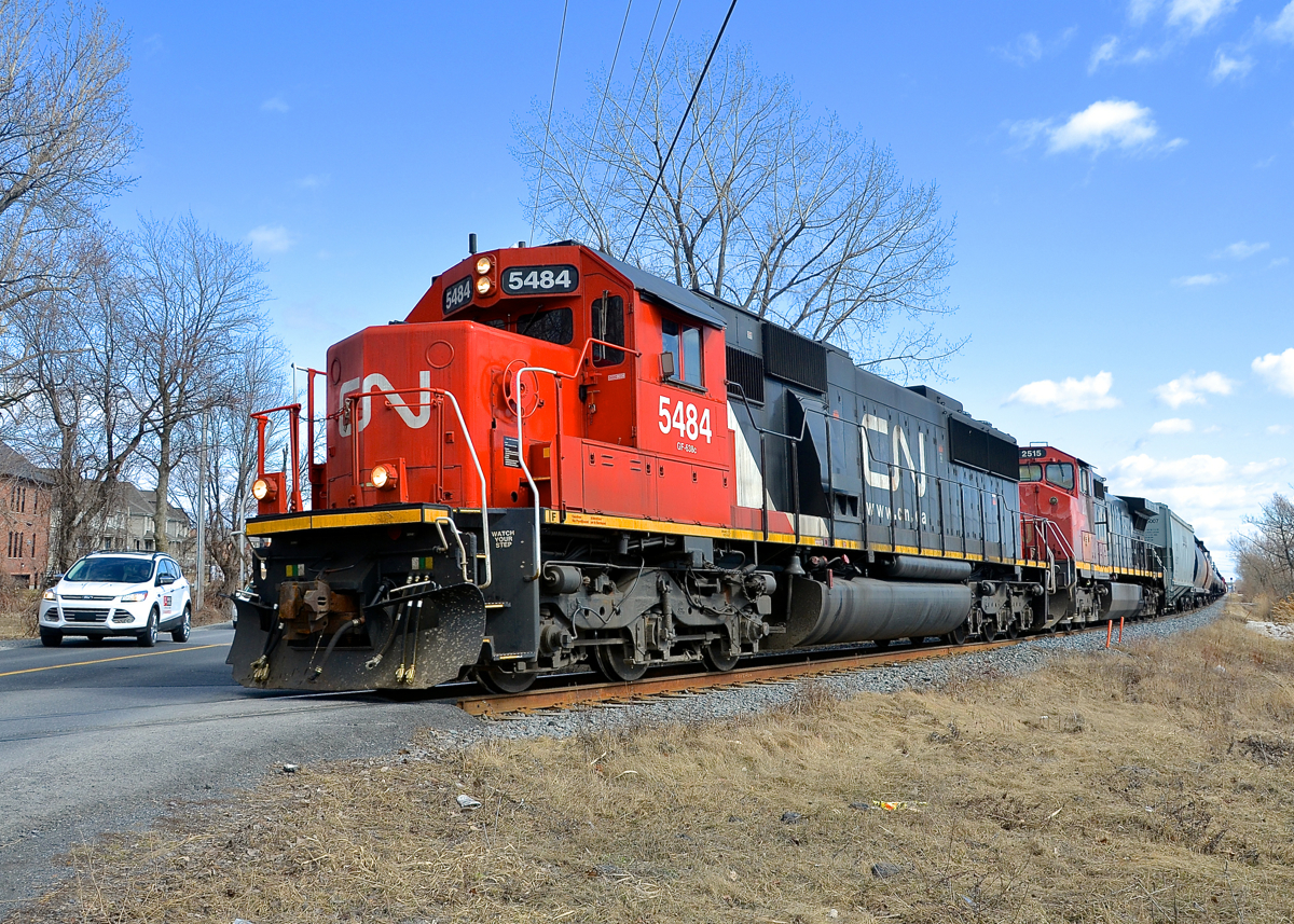 Railpictures.ca - Michael Berry Photo: CN 323 has CN 5484 and CN 2515 as it  prepares to cross Chemin des Prairies in suburuban Brossard, on its way  back from St. Albans, Vermont