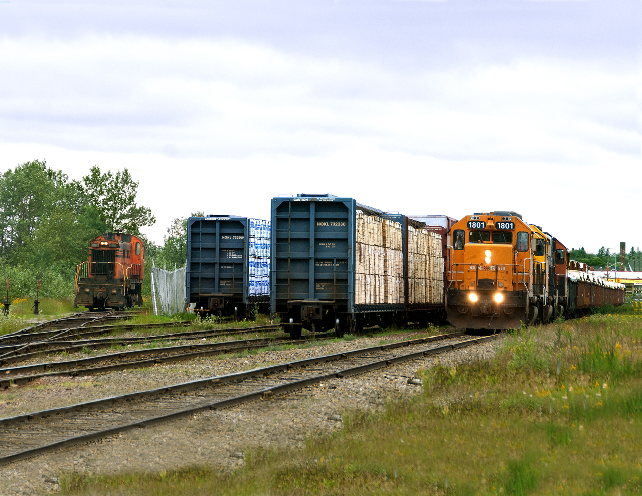 Ontario Northland's eastbound from Hearst to Cochrane pulls up to the east end of Kap yard to lift loads spotted by Tembec's RS23 seen on the ladder track heading back to the mill.