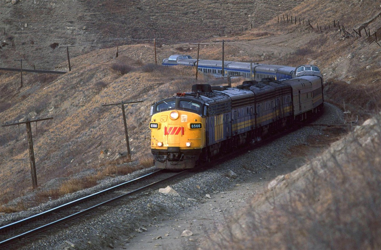 The eastbound "Canadian" is just east of Cochrane along the bluffs that bound the Bow River. Unit 6566 was a regular on the train at this time.