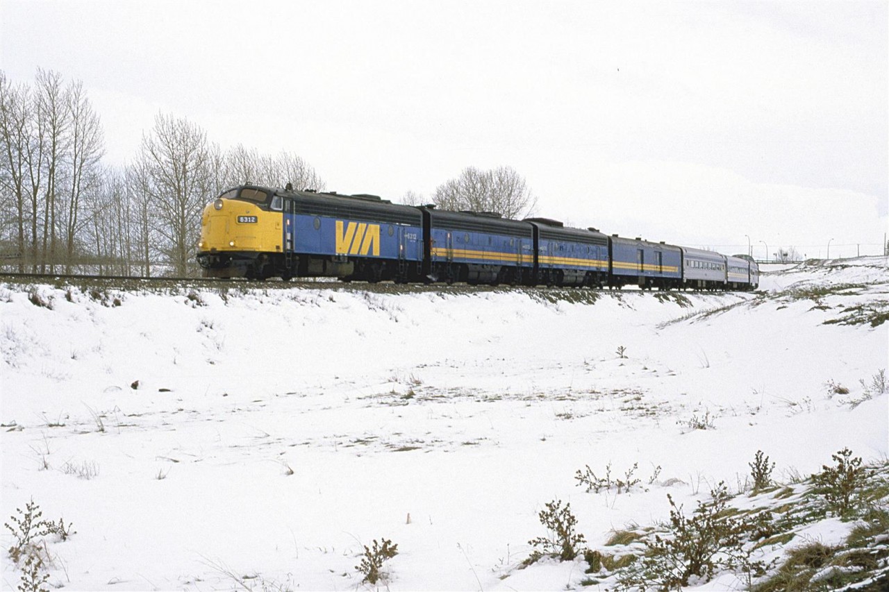 Note the date. This is mid-May! It happens periodically. Alberta will get a Spring snow storm that will dump 10 -20 cm of snow.
Operations on the CP were definitely affected. There was not much running, but the eastbound "Canadian" arrived about an hour late. I don't think that I saw the westbound version in the time I hung out by the tracks.
It is about to cross the Bow River.