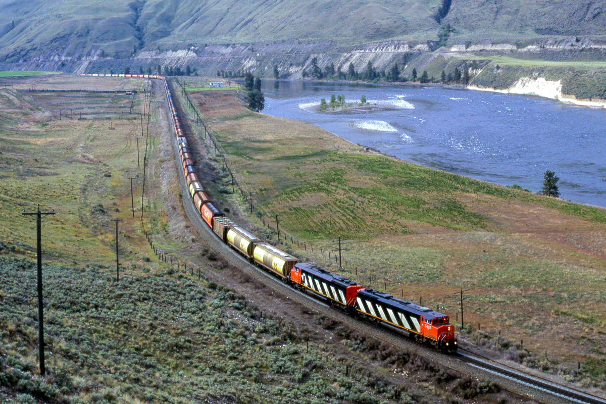 If you see this photo, it is thanks to Joseph Bishop. He was able to edit my original scan to something that was acceptable.
Here is a westbound grain train just east of Juniper Creek Provincial Park. We would find these two lead engines sitting in Boston Bar later in the day. The train was taken west by other engines, I presume.