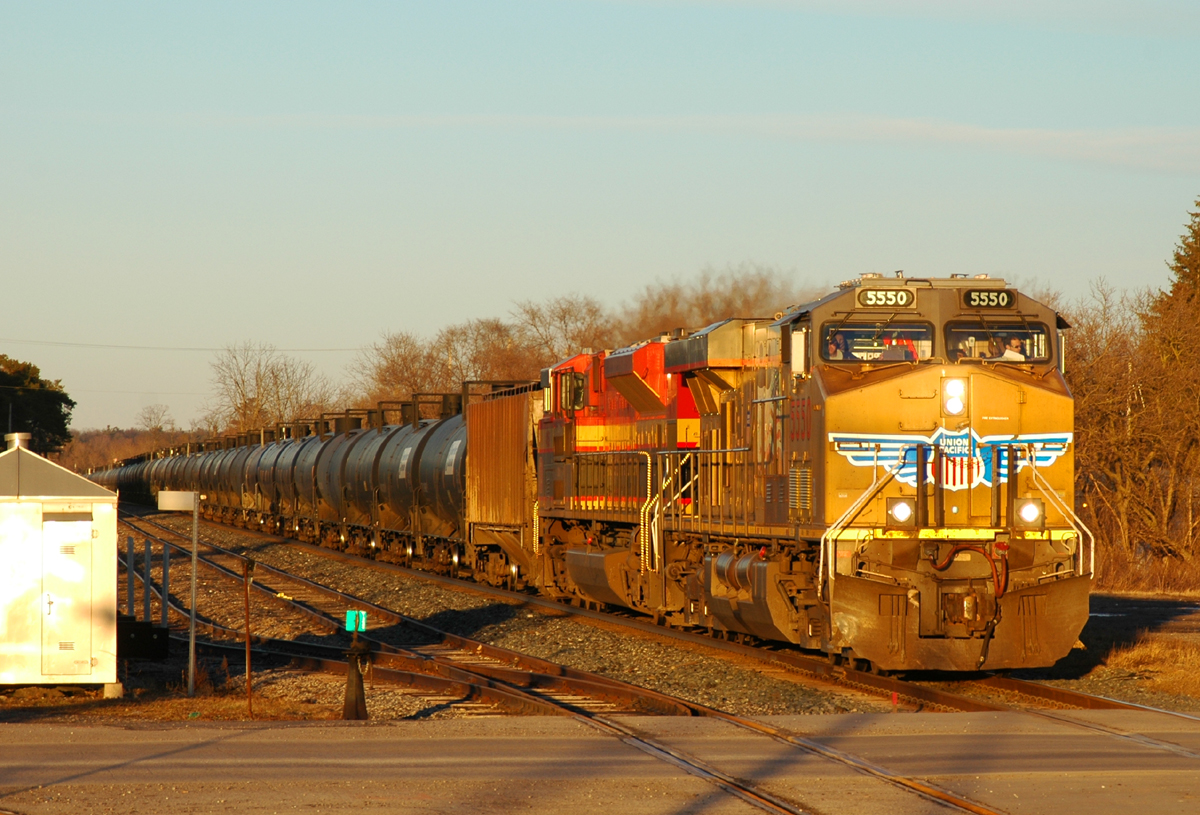 UP 5550 and KCS 4166 lead a short 80 car 647 through Ayr, ON in the last rays of sunlight