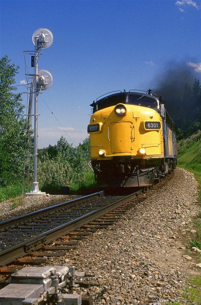 The westbound "Canadian" is smoking it up as it accelerates at the east end of Brickburn siding. The remote control motor for the switch is seen in the forground.