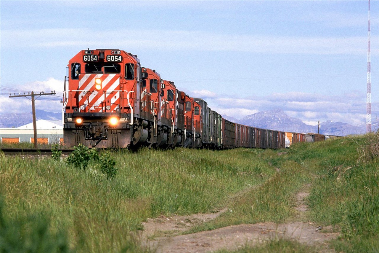 This is CTC Board's Day in the West II. My wife and I went out to Cochrane. As usual for that time, we did not get an early start, although 0838hrs would seem early to some folks. This was the longest day of the year and the sun had been up for a few hours already.
This is an eastbound manifest with what are likely wood products on the head end.