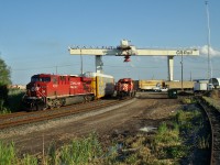 Train 113 backs into the work track at the Vaughan Intermodal terminal while a yard SD40-2 sits waiting for it's crew. To the right of the radio antenna tower is the curved roof shed for salt/sand storage and parked by it's base is a mobile service truck.