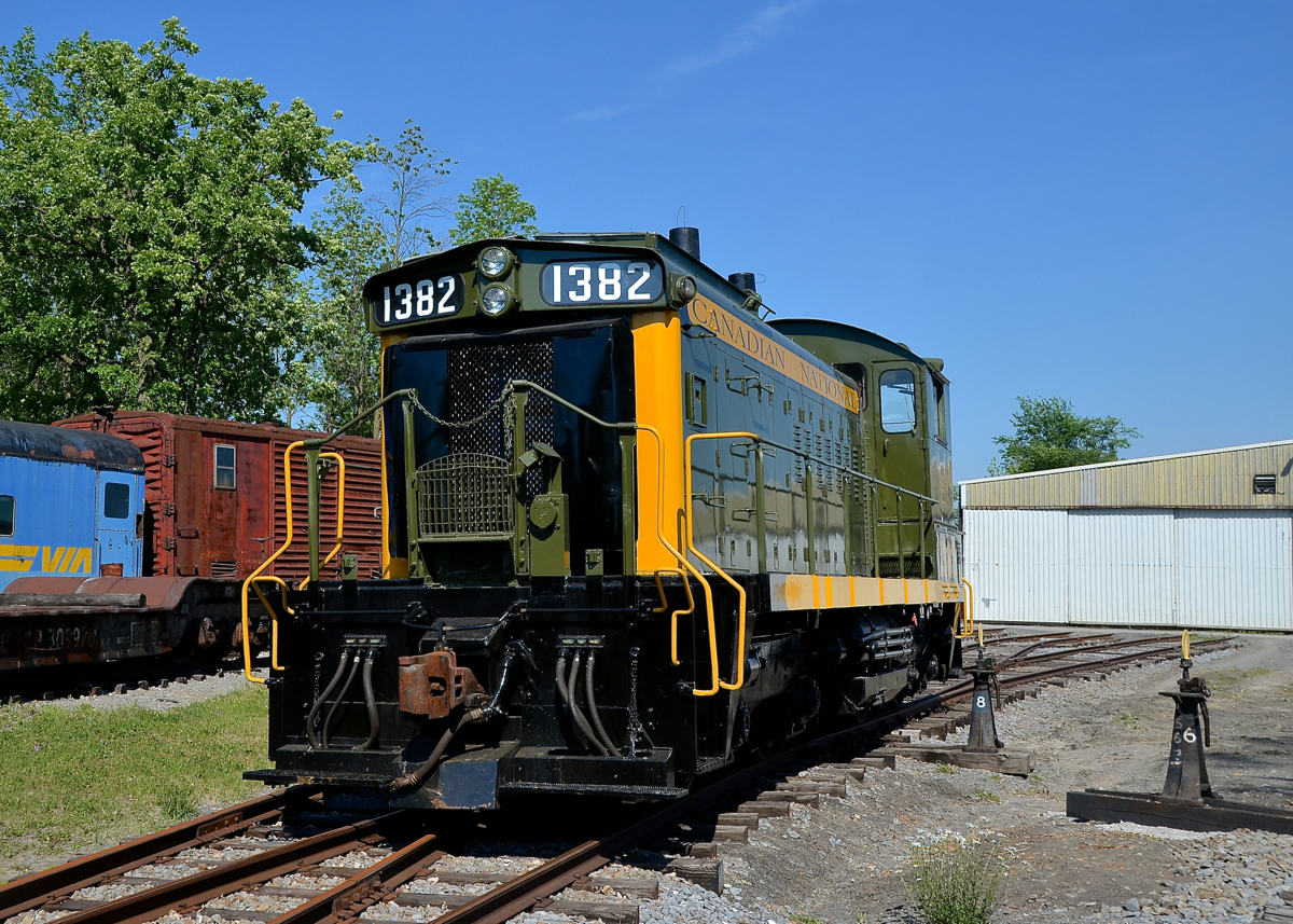 A preserved end cab switcher. CN 1382 (formerly CN 7300, and donated to Exporail during the summer of 2014) is parked in front of one the hangars on a very hot and humid day.