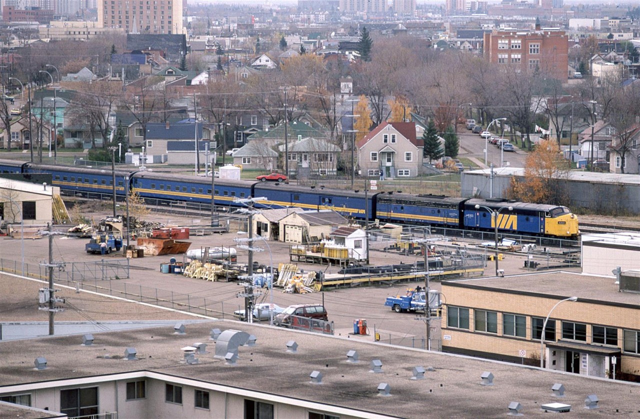 No one is going to call this a great photo, but it is from a relatively unique location - from my apartment on Jasper Avenue (whose rent is probably astronomical compared to back in the depression of '86).
I had watched this train several times, but finally took the time from my studies and pulled my camera out.
The train has finished the stop at the station and is headed NE back to the mainline at East Junction. This loop track to the downtown dates back to when the CN was a series of RR's that came to Edmonton.