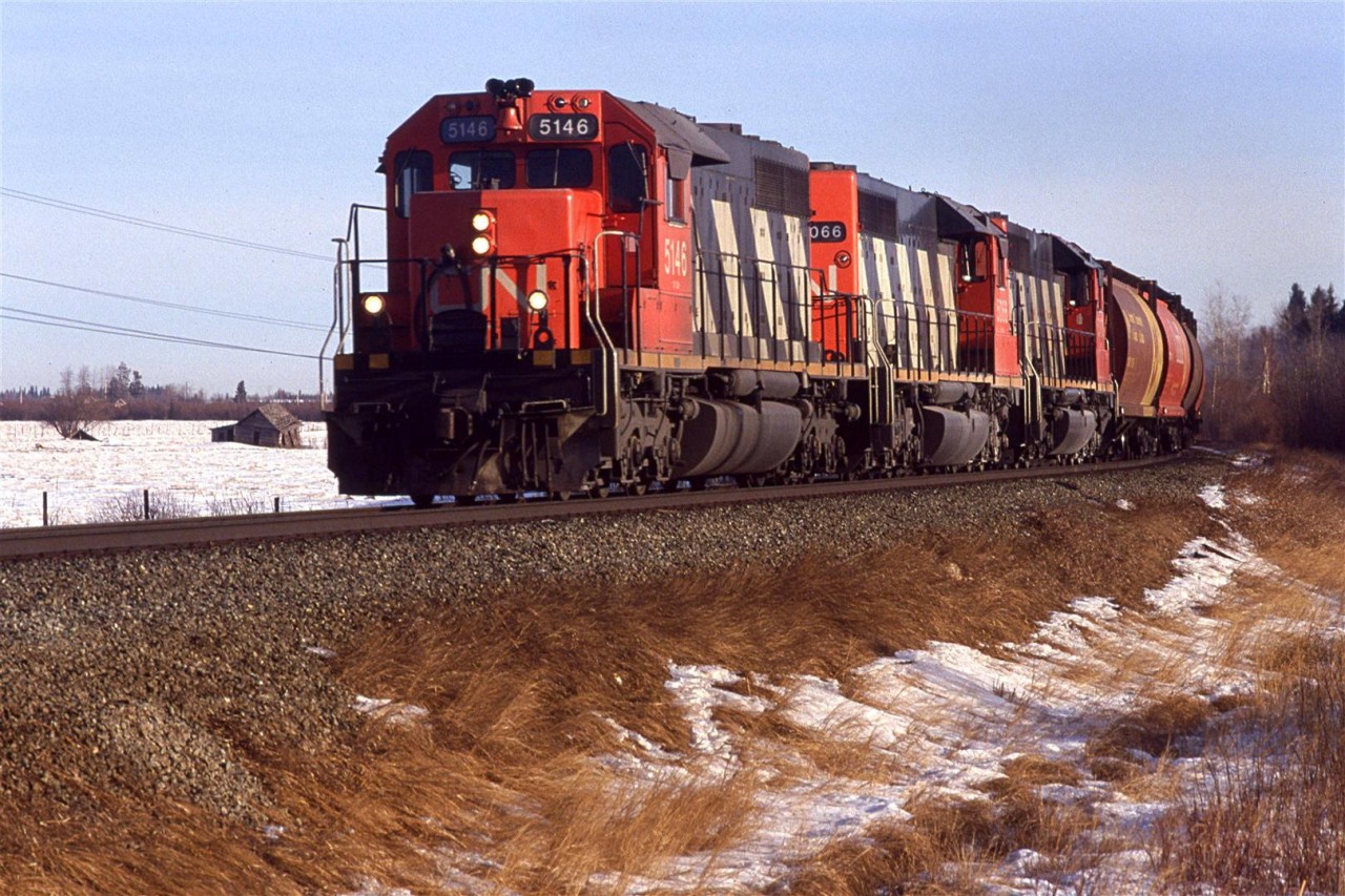 We went east of Edmonton, along the Wainwright Sub on the 19th, and found it to be relatively uninteresting (remember, I had just moved from Calgary, where there were hills and twisty track). We then tried the Edson Sub, west of Edmonton. Also remember, this is way before Google Maps. Topo maps were all that we had.
We found this spot along the shore of Chip Lake, just off the highway and waited. It got cold in the car without full sun - there were some thin high clouds much of the day.
Finally, this westbound grain and potash train came through. I lucked out and it did not have a wide nose SD-40 leading.