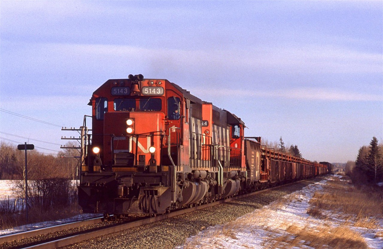 It is getting late in the short day - possibly the shortest day of the year, and a westbound welded rail train is approaching Wildwood. With the thin clouds and the low sun angle, you would get this greenish light up that way in the winter.