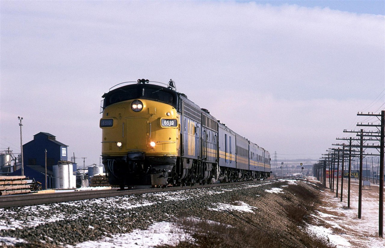 An abbreviated "Super Continental" is arriving in Edmonton. The Domtar facility is still intact at this time. They applied creosote to ties there and pretty much became a Canadian equivalent SuperFund site. After the razing of the structures, a giant tarp was put over the mound of contaminated soil and debris. Groundwater was pumped out and treated or burnt. That went on for well over a decade. The land is still not developed, but housing abuts the site to the east and west.
The train is on the Wainwright Sub and has just crossed the high bridge over the North Saskatchewan River, just beyond the set of signals seen in the background.