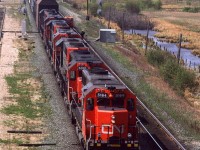 An eastbound auto train is approaching Edmonton. Note the beefy high railcar just behind the locomotives. It is there to clear ice from tunnels thus protecting the expensive automobiles following. Note the date.
A train with seven locomotives on the front end was very rare on CN. Typically, CN would run a train with only 2 engines on the mainlines in and out of Edmonton.