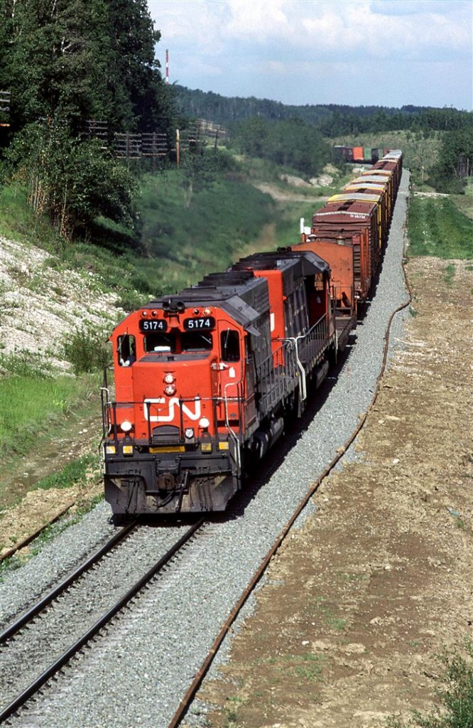 This westbound is about to duck under Highway 47. This road leads into the coal mines of CN Foothills Subdivision. The railroad connection is a couple miles to the west of here.
In the background, out of sight around the corner, CN crosses Hornbeck Creek on a reasonable sized bridge - one that I never had time to photograph.
The train looks to be one of the empty wood trains returiong to Prince George, BC - likely #357 or #359.