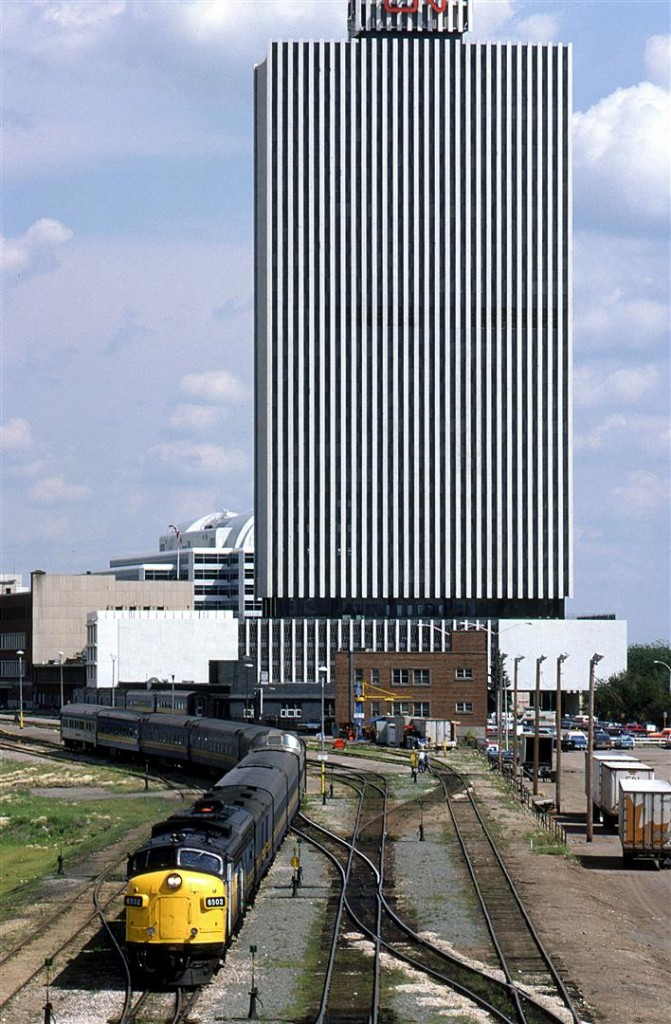 At 1428hrs, the westbound "Super Continental" pulls out of the VIA station in downtown Edmonton. At this time, the loop track off the CN mainline to the north was still intact. That would not last. Big change was about to happen as virtually all of the RR activities in the downtown were about to end. There was a yard in the opposite direction of this scene that served a few industries in the area, but seemed to mostly handle interchange with CP. Once that yard was abandoned, the bridge that I was standing on would be removed. VIA still used the downtown station for a number of years to come, however it required a reverse move from (or to) East Junction (to the NE of here). 
The first re-development of the land made available by lifting the rails was the Grant MacEwan College (now a University).