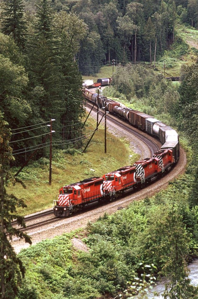 It took me a while to locate where I photographed this train. Google Streetview showed that the trees along the highway have obscured this view.
This is an eastbound manifest working hard up the west slope of Rogers Pass.