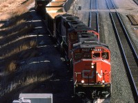 A sulphur train heads west out of Bissell Yard with 3 GP-40's leading. This train originated in the Kaybob area, and will deliver the sulphur to North Vancouver for export.