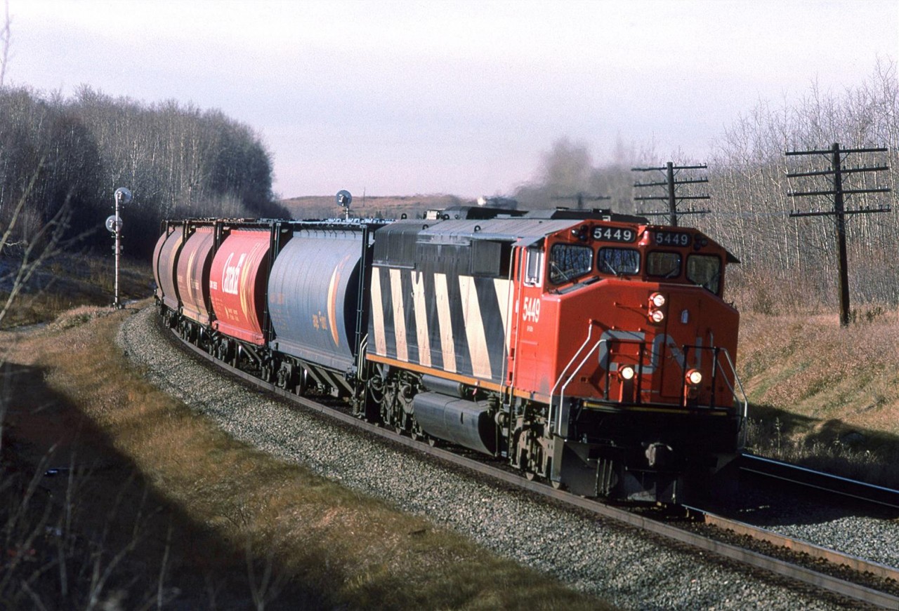 I know that in this day and age, people might think that this is the rear of the train. What, only one engine leading? This was more common than you might think, particularly with empty grain trains. 

Hello Trevor or others in the area; I was wondering if there is a photo eastward from that hill in the background?