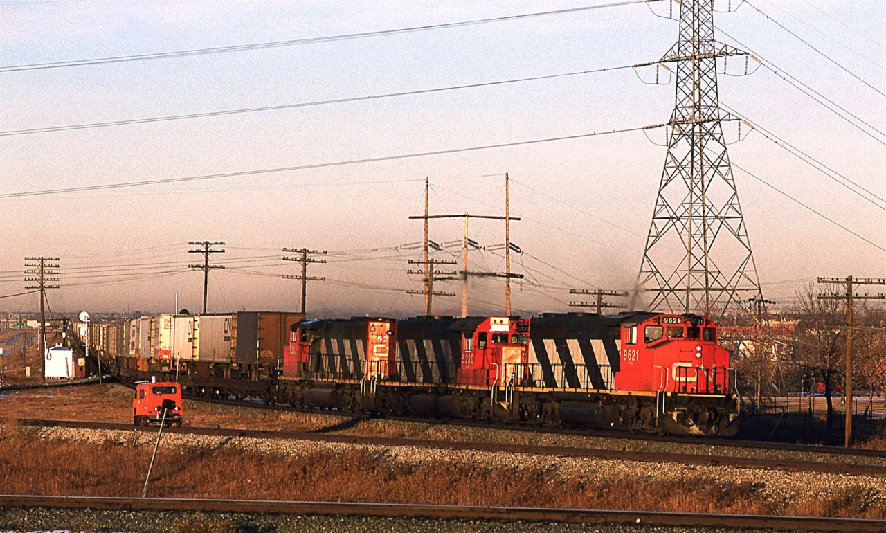 By the low angle warm lighting, one might think that this is an early morning shot, but in Alberta in mid December, it is actually 0930.
A long train to dominantly TOFC snakes out over Bretville Junction, and the crossing of the North Saskatchewan River. The speeder is on the a weird track that that parallels the Wainwright Sub that forms the "top" of the wye on the Camrose Sub (Best seen on the map/satellite photo of the area).