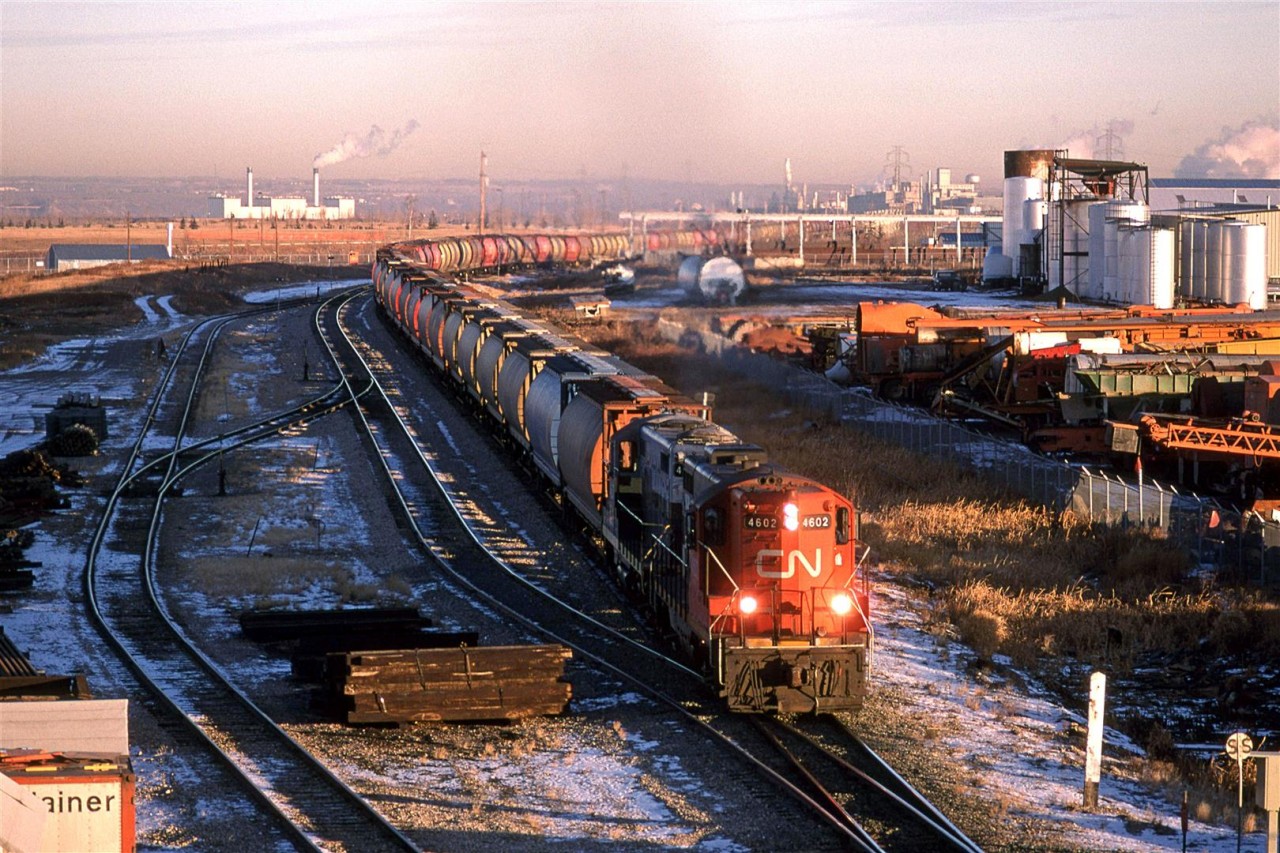 It is hard to believe that it is almost 10 am, but this is what you get at latitude 53.
We have a southbound empty grain train on the Camrose Sub in east Edmonton. #820 was a fairly common train, therefore, i am led to believe that it dealt with elevator on the Camrose and Three Hills Sub's between Edmonton and Calgary. Other options south of Edmonton seem unlikely. The Alliance Sub (SE of Carmose) and the Brazeau Sub (West at Mirror) did not seem to have that many grain facilities to account for all the #820's that I would see.
The power seems a little strange for a secondary mainline train. We have two high-nosed GP-9's leading - one still in NAR colours. Had I been able to drive, or if my wife was there, this would have been a fantastic train to chase. That wasn't going to happen on my bicycle.