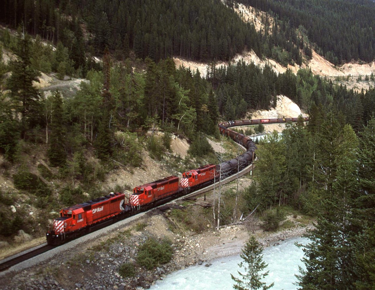 In order to show my railfan acquaintance how one can chase a train from the summit of Kicking Horse Pass all the way to Golden - the area covered by his planned guide, we decided to chase this train. The next several photos were all taken from roadside locations. This was our eighth photo location, from a now removed bridge that hosted a muck more dangerous routing of the Trans Canada Highway through this area. I don't believe that this shot is reproducible now, but the old highway is still there and a better shot may exist now that the bridge is gone. I have not see any shots from the new bridge. I suspect that the view upriver is not all that spectacular though.