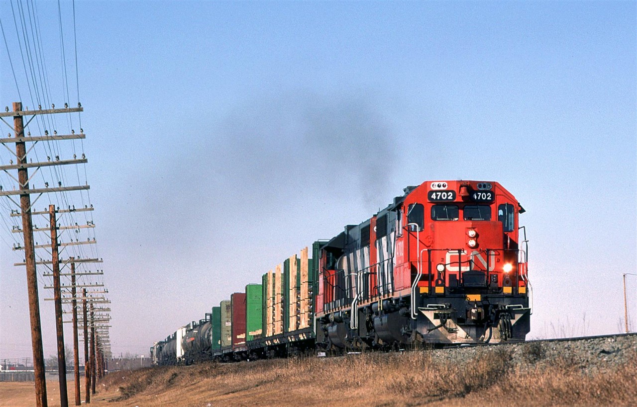 Looking a lot like a local, this regional train, #452 from Edmonton to Winnipeg is just beginning its journey on the Wainwright Sub out of Edmonton.
The pole line is still there but not for much longer. Look carefully, there is still a caboose on this train.