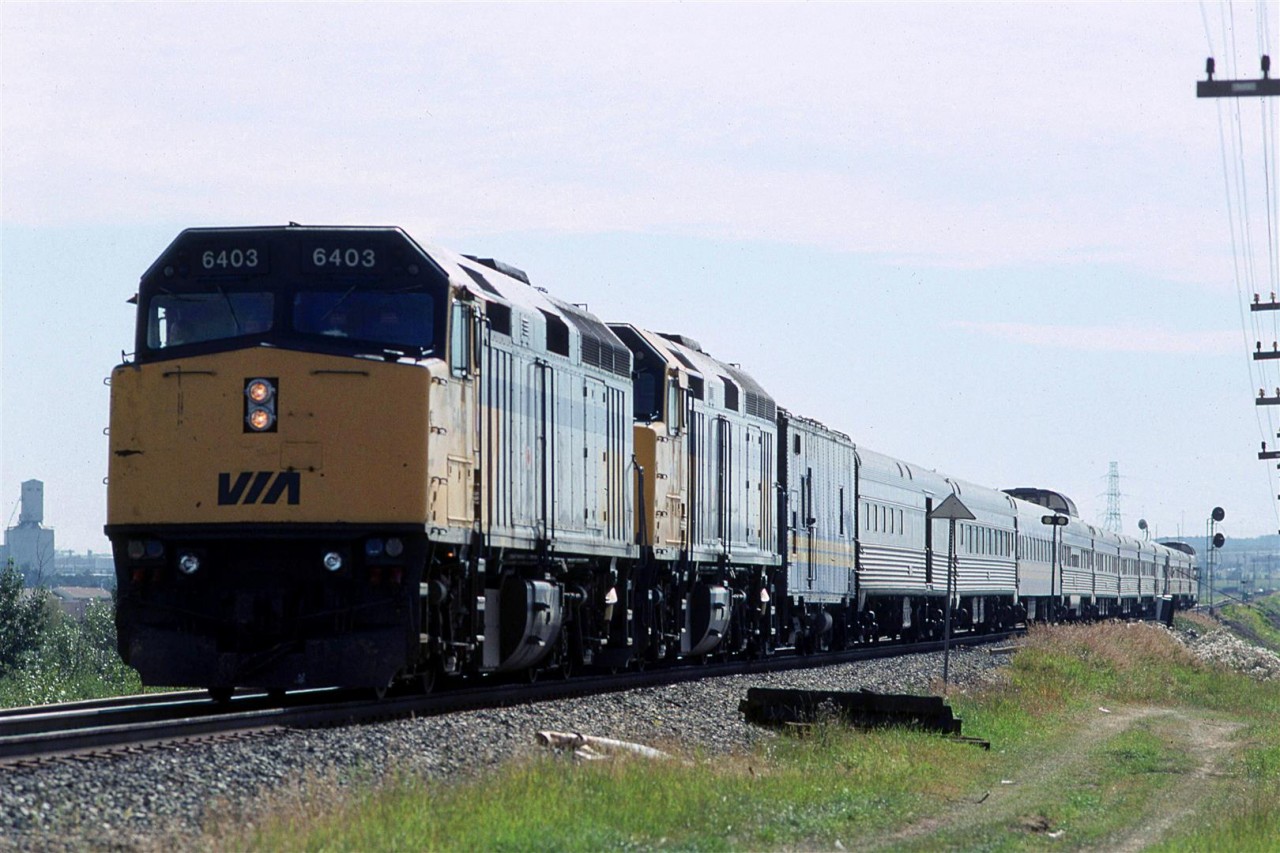 This is my first photo of the "Canadian" running trough Edmonton. With the demise of the "Super Continental", VIA had lots of surplus equipment, therefore there were no more mixes of old and new power on the transcontinental trains, and stainless steel cars dominated the scene.
The unfortunate souls on this particular train were forced on to a bus because of a track closure west of Edmonton. The westbound train terminated in Edmonton, and this became train #2. It has backed up the spur from downtown Edmonton and is continuing to back down the Wainwright Sub to Bretville Junction. It will use the wye at that junction to reverse direction and return to Toronto.
It looks like the double tracking at Bailey is not complete at this time. The tracks don't look to be fully installed and the signals for the end of the double track are still turned to the side.