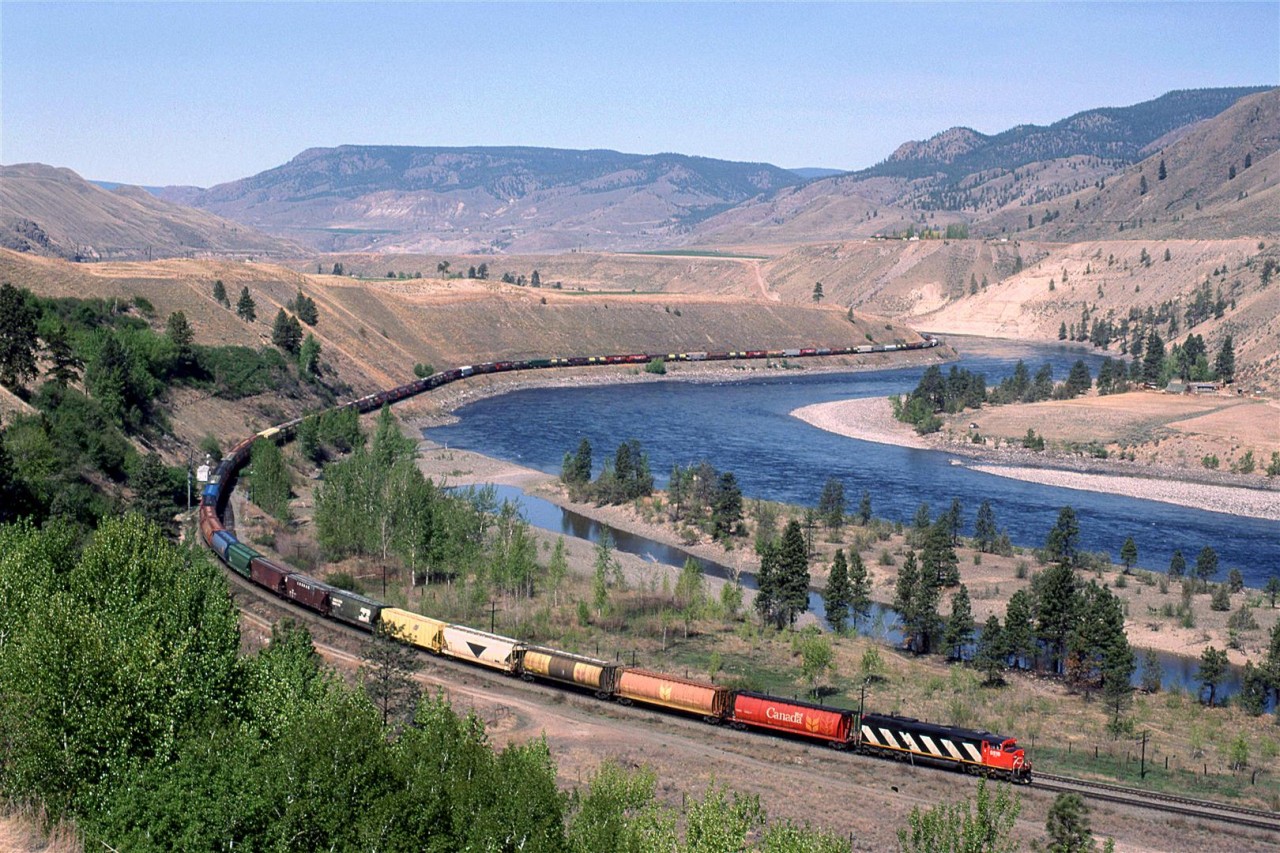 An eastbound empty grain train cruises up stream along the Thompson River below the village of Walhachin. Single units were often seen leading such trains out west.