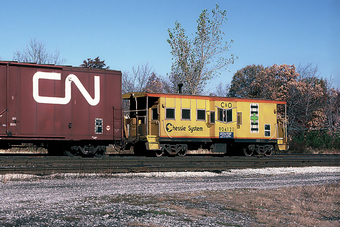 Chessie System C&O Caboose 904121 on a westbound CSX freight is leaving the CP yard after it stopped for a crew change. October 26, 1987