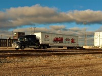 Transport carrying the Canadian Pacific "Little General" mini train arrives at Agincourt Yard. The mini train is used for special events and is probably here in advance of the Holiday Train's arrival.