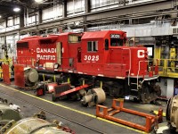 This GP38-2 is seen in the process of having it's main generator changed out. The roof section directly behind the cab has been removed and sits on the floor beside the unit along with the inertial blower motor (just in front of the first axle).