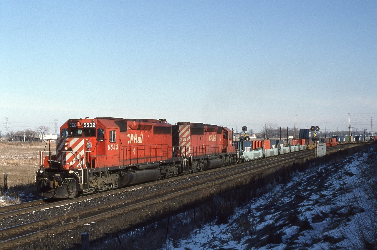 CP5532-CP5728 have just crossed Winston Churchill Blvd (Mississauga, Ont) and are about to crest the grade out of the Credit River valley at Mile 25 Galt Sub.  When I lived in this area I was able to see the track at the Mile 25 detector out of the back window of my house. Westbounds were usually moving slow enough I could beat them over to Hornby. Then they built another housing subdivision behind me and blocked my view. So I moved.