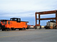 Ontario Hydro caboose poses in the Vaughan Container Yard while a MI-Jack crane places a container into a well car.