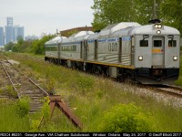 Three of VIA's rebuilt RDC's, led by RDC4 #6251, roll eastbound at George Ave. in Windsor, Ontario on May 24, 2017. In the background GM's World Headquarters looms in Detroit as a reminder that this is a modern photo and not something take in the 60's when RDC's were still relatively new.  As part of the Memorial Cup Tournament hosted in Windsor this year, VIA helped promote the event by shuttling school students to/from the Windsor Station to the WFCU center to enjoy a display explaining the history and meaning behind the Memorial Cup as well as teaching the children about safety around the railroads. Very impressive site seeing a trio like this again. 