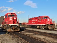 2 SD40-2's await the encroaching shadows at the shop's west end. The 5879 still with a faint hope of returning to snow plow service in the upcoming winter and the 5698 now long gone and working in the US.