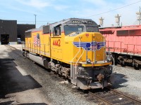 A fresh Union Pacific SD70M parked outside the shop's east end.