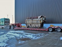 The engine from CP SD40-2 5864 sits on this rigs lowboy trailer ready to back into the shop to be covered for transport.