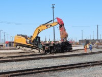 The "torchmen" watch the action from the sideline as the CAT digs in and tears into the frame of CP 5824. 