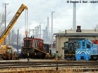 Action at the CN Sarnia Roundhouse on New Years Eve as CN  1437 gets a new combo/wheelset provided by the capable men of Lambton Diesel Services. To the right is the usual motly crew of Switchers owned(?) by LDS including: Esso (ex CN) 7920, General Electric (SSRX) 911, and the black one is 1515 with LDS lettering on the sides. The Esso unit has been here off and on over the years, usually for repairs, but now "6900" former EMD switcher is at the Esso plant and this one has been at LDS ever since (a few years now).