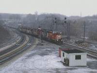 You could say a TH&B train with CP power on CN track.
What a crummy day. I remember this Sunday rather well. It was early spring (yep!) and it was totally miserable but a lot of guys were out as the 'spring fever' was in the air. Until today. Damp wet snow took away the sharpness we would have otherwise had in the days' photos.
Having nothing else in mind, I hung in for the Starlite after almost everyone else had left; and it rolled along just before the dinner hour with 7 units. Can't find my notes. Only notice lead unit is CP 5725 and there is what looks like an CP RS-18 on the end behind the 4 horses of the TH&B.
Of note in the extreme background is the chimney of the old Burlington Brick plant, long demolished.
This image, BTW, was shot with Sakuracolor print film using a Pentax K-1000.