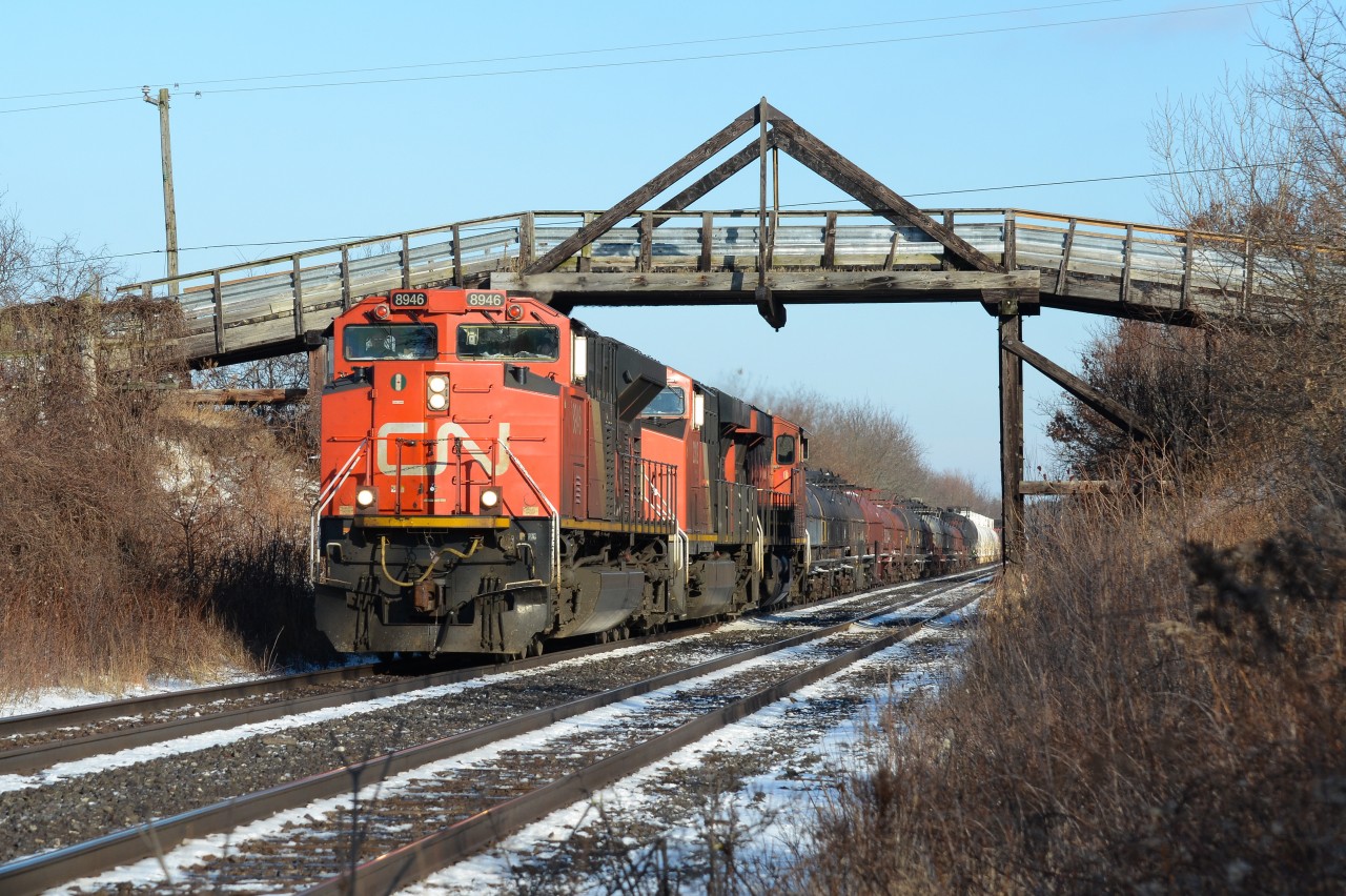 Definitely not the coolest thing on CN’s roster up in lead, CN 331 (when it existed) drags it’s 150 car train down hill towards Komoka Junction passing under the scenic bridge at Franks Lane west of London that goes over the CN here, and under the CP to the north (left). The Kingpost truss bridge apparently was a rare form of truss bridge that had metal supports on the vertical parts on both sides as the rest of the bridge was made from solid wood. It definitely makes for a better picture location shooting the train going under this cool piece of infrastructure then standing on it shooting the plain straight double track and farm fields.