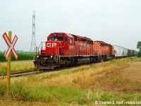 Caption: D725 is travelling southbound along John Park Line near Wallaceburg with 90 or so cars, the track followed this road for a few KM and made for easy chasing. It was stupid easy between here and Dresden, about the same as Chatham to Blenheim :) Good news is the track is still in place, and being sold to a numbered company as I type this - with a small chance for a Resurrection. Bad news - no trains since 2013.<br><br>I'm still amazed at the progress and change in this hobby. The number of people out these days is great, an order of magnitude more people than there was in the mid 2000's. Here's my example to compare: Back in Summer 2005 the rumours were rife that the end was coming to the CSX in Sarnia yet there were so few photographers out for this. I had coaxed some friends (Brian Switzer, David Graham, Laura New, and Chris Vanderheide) to come shoot D725 on Saturday July 16 as I had chased on Friday July 15th both ways. Travelling in a convoy we had a blast chasing and the friendly CSX crews made it even better. It was fun and worth getting off our TODO list. Compare to the number of people that are going to Chatham these days for the Blenheim run - the comparisons are unquestionable - you have a half dozen people shooting Blenheim every Saturday these days but when I shot this run I was most often the only photographer (or with the crew I took with me, and we found no one else) - and I shot it a dozen times including the second last run - even on that run (a Saturday) I was the only one out. I do recall one run where I met David Patch (from Toledo), and the Windsor gang (Geoff Elliot, etc). If this happened today, you'd have photo lines of a dozen people.<br><br>Blenheim today is at best once a week (more like every two weeks) but in 2005 D725 (mon to sat) and D724 (tu,th) ran through here in daylight - that 8 trains a week! Starting in February 2006 they were down to just the Tuesday/Thursday Sarnia-Dresden turn (D724 - two per week) until 2013 when it all stopped - and I recall a number of young chasers getting it before it dissapeared like <a href=http://www.railpictures.ca/author/myles-roach target=_blank>Myles Roach.</a> and others.<br><br>Today, because of the Internet, everyone is falling over each other to replicate what others have done, or get it done before it's gone because news spreads fast - and this is adding to the crowds - yet a short time ago it was just not the same. I'm pleased to see the growth in the hobby - everyone welcome! Get your shots while you still can. And if in the rare chance this is resurrected, you know where I'll be on opening day.