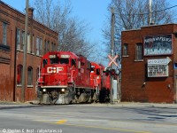 After spending hours switching in North Hamilton the Kinnear yard job TH31 is seen passing between the buildings at Main and Gage on the former TH&B Belt Line. It has been a few years since I've shot here, the last time the motive power was a <a href=http://www.railpictures.ca/?attachment_id=8198 target=_blank> trio of GP9's </a> and this time a trio of GP38-2's making for a nice contrast. 

