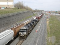 A rare daylight with NS 1002, NS 4332 and 25 cars is passing a CN 527 at left as the conducor gives a wave.