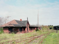 The short-lived Windsor and Hantsport Railway operated on some former Dominion Atlantic track for the most part; servicing two Gypsum quarries in the area. The line once ran as far west as New Minas, but economic downturn resulted in that part of the line from Windsor westbound to be embargoed.
The closing of the two gypsum quarries in 2011 spelt the end for the WHRC.
The old Hantsport station was in the news a couple of years ago, as the town wanted to save the structure, but it seemed no one had the cash to have it shored up against the vandals. So there it sits.
In the background to the right in this photo one can see there are a considerable number of old hoppers still on the property. The line is severed toward Halifax for a short stretch and so the cars remain to rust.
Owner of the line, An American, still thinks he can get this road up and running again, for whatever reason, as the track is intact all but for a short washout. Rehabilitating this line seems like a supreme waste of money. In the meantime, Mother Nature moves in.