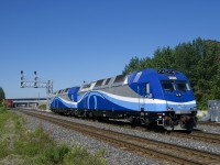 A pair of consecutively numbered ALP-45DP's (AMT 1353 & AMT 1354) are heading west light power, to be transferred from commuter lines that run on CN tracks to those that run on CP. It is approaching a CN 148 which is stopped while a signal maintainer does some emergency work at Pointe St-Charles.