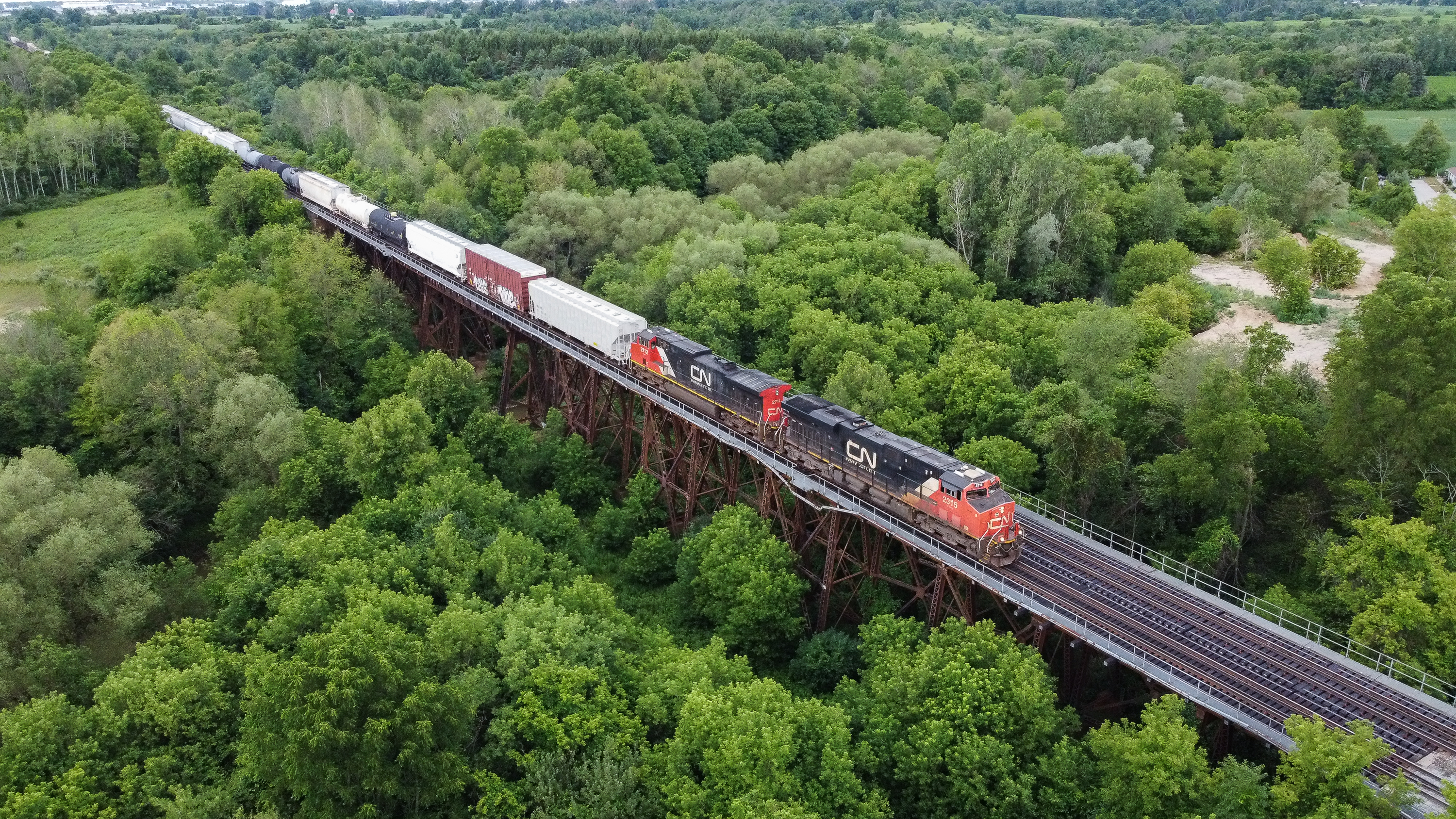 Railpictures Joseph Bishop Photo CN 396 blasts over the Fairchilds Creek Bridge with CN 2315 and IC 2712. This trestle is rarely seen or photographed because of being very overgrown and