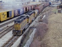 Busy day at old Fort Erie. Morning fog is lifting, leaving an annoying haze in the air as Chessie 3820 and 4296 arrive from the USA with a short transfer. Not often did they go around the south side of the sprawling CN complex, but on this day they would continue on to namesign Fort Erie South and go in 'the back' way. Not sure of the string of empty cars in the scene as well. No power attached. 
Fort Erie MCRR/TH&B station still looks good. It would not be around much longer.
