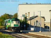 The last Eastbound GO train of the day is passing new and old city hall in downtown Guelph. The old city hall with the old stone secondary building seen was built in 1856-7. The new was built around 2008-2009.